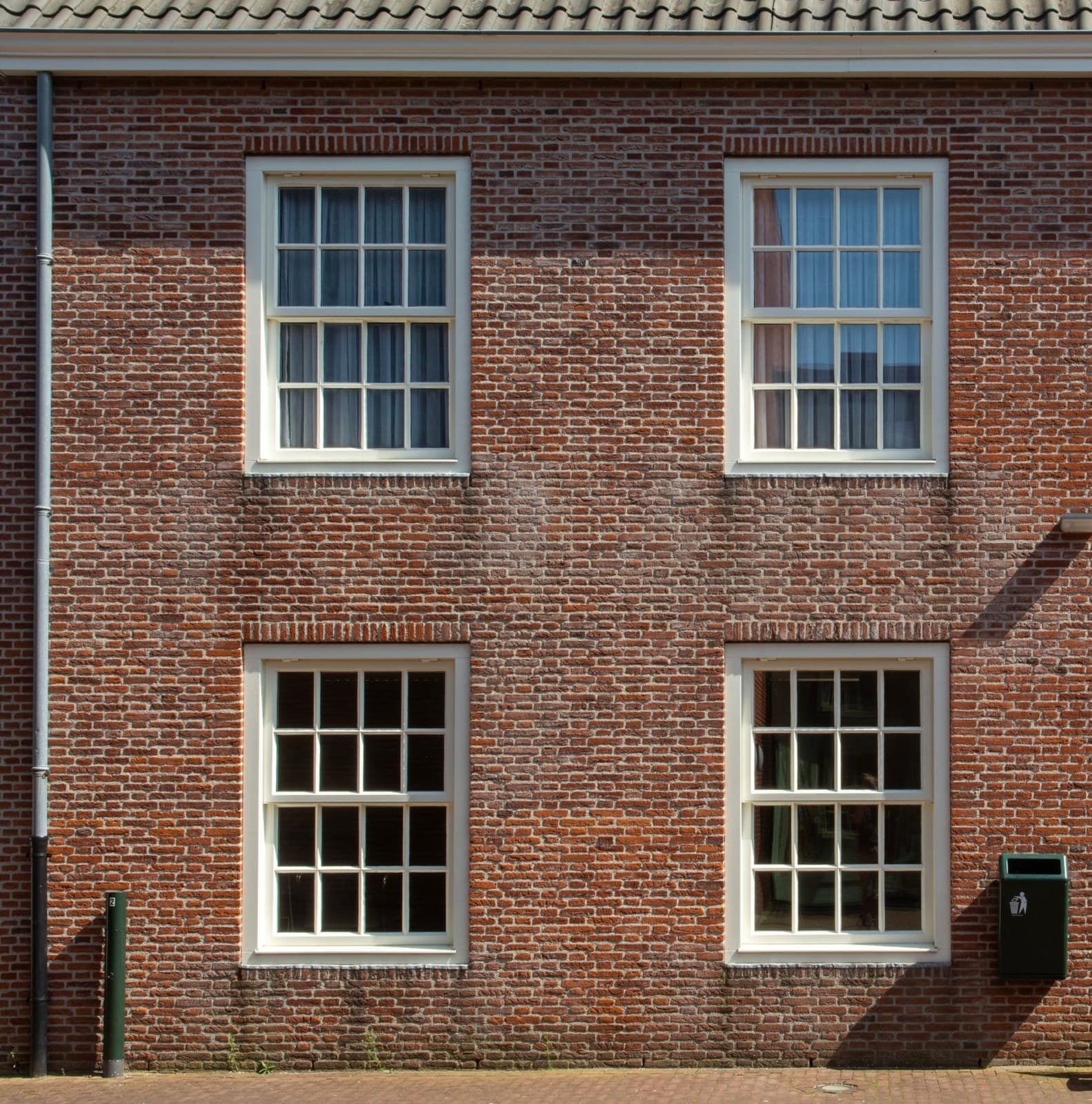 Brick facade with rows of white double hung sash windows