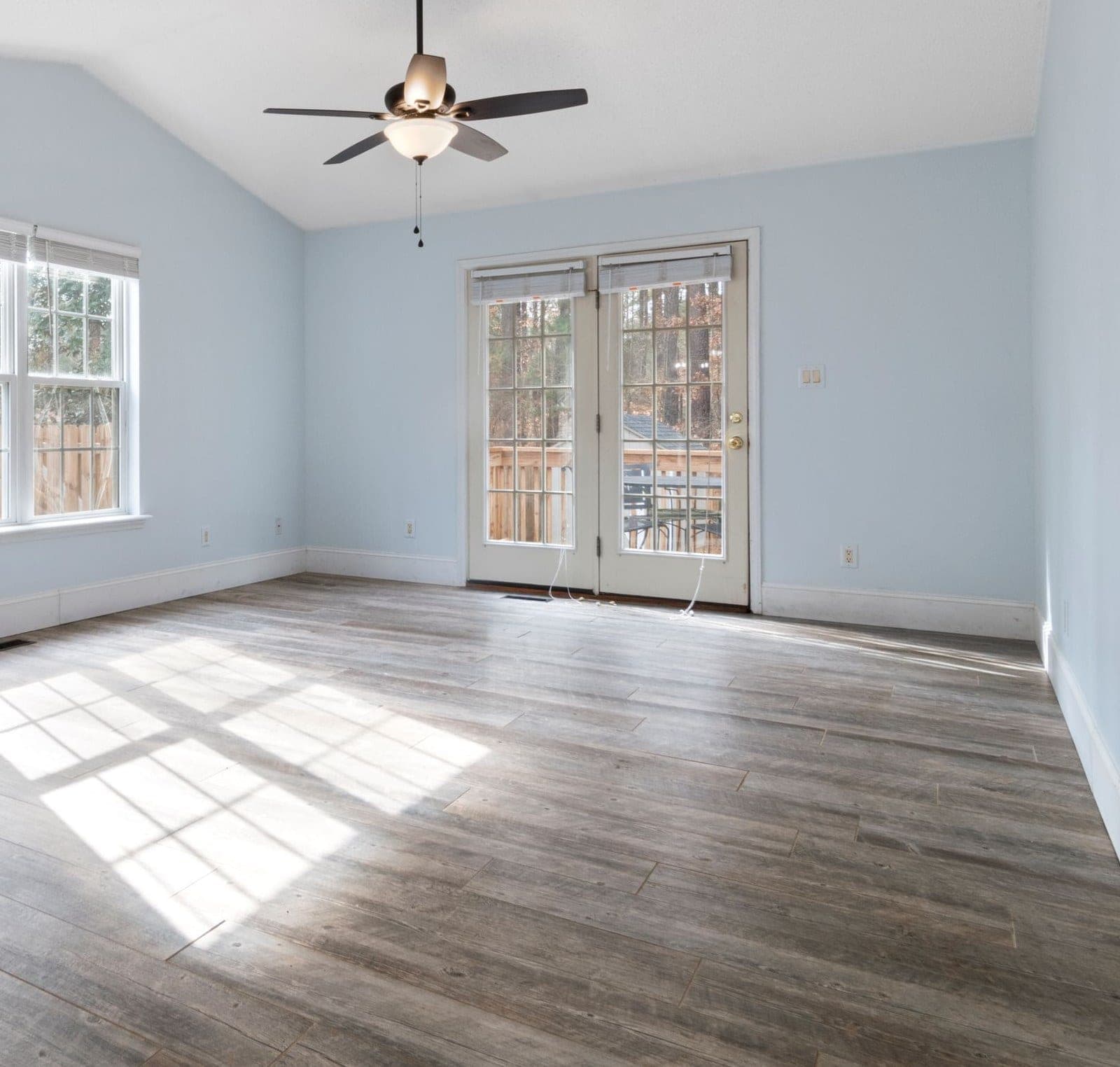 Bright empty room with hinged glass garden doors at the far wall
