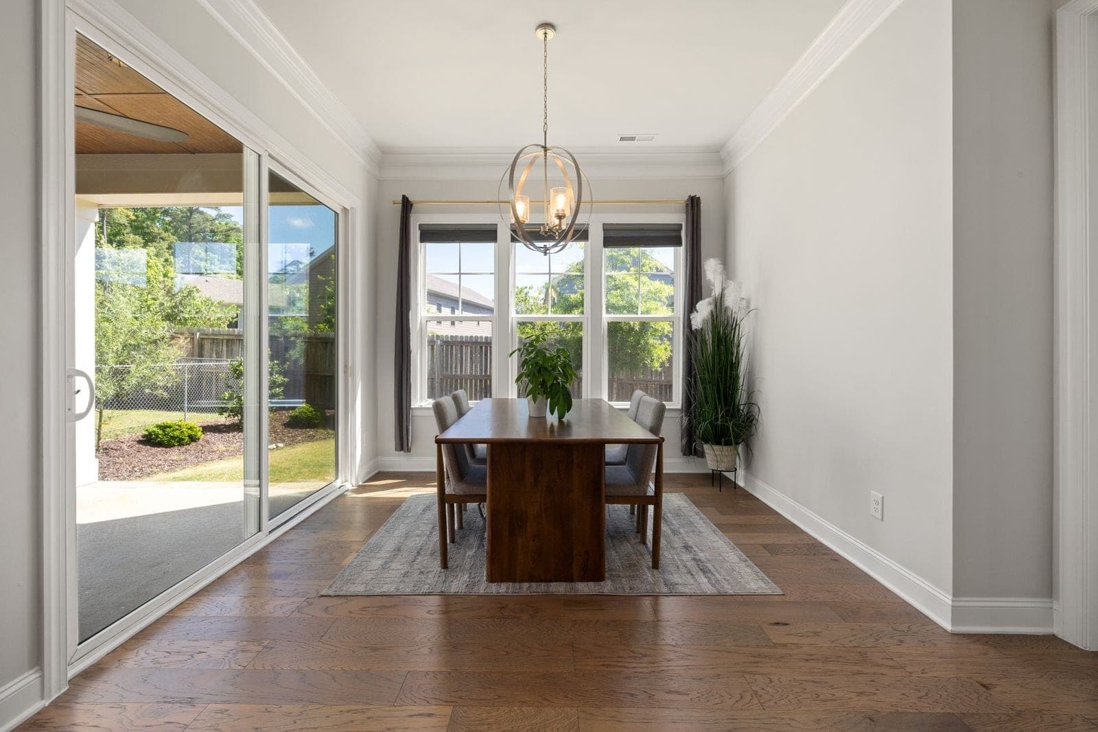 Dining room with a wide sliding patio door open to a backyard